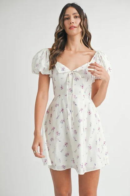 Off-white MABLE floral print puff sleeve mini dress by Trendsi, featuring a fitted bodice, short puff sleeves, and a feminine silhouette.