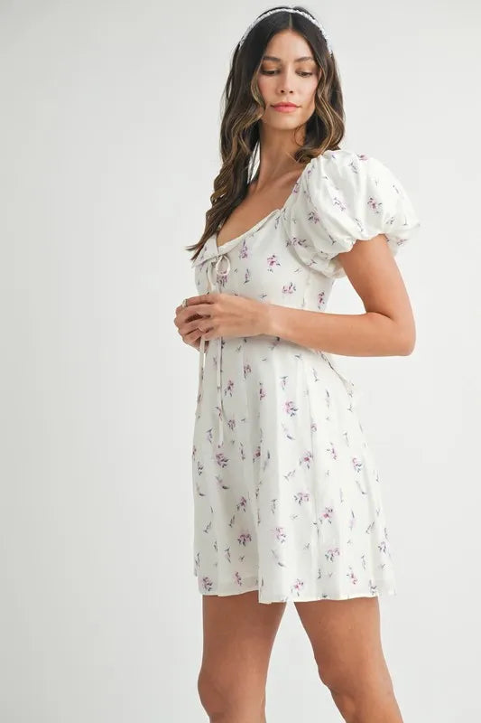 Off-white MABLE floral print puff sleeve mini dress by Trendsi, featuring a fitted bodice, puff sleeves, and a flared skirt.
