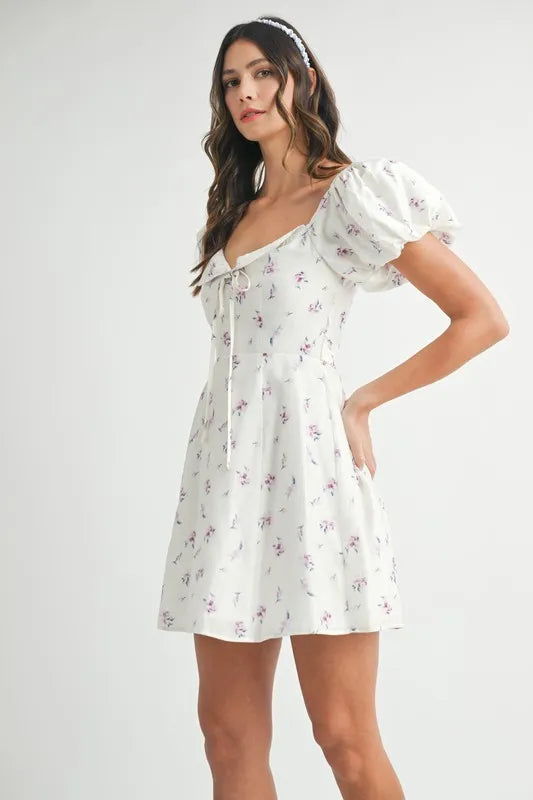 Off-white floral print puff sleeve mini dress by Trendsi, featuring a fitted silhouette and ruffled sleeves for a feminine look.