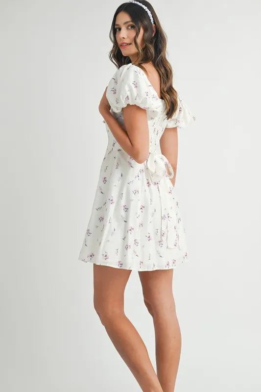 Off-white MABLE floral print puff sleeve mini dress by Trendsi, featuring a fitted bodice and short puff sleeves.