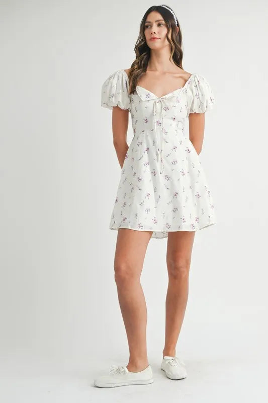 Off-white floral print puff sleeve mini dress by Trendsi, featuring a fitted bodice and short puff sleeves.