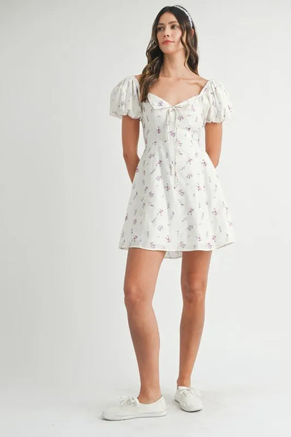 Off-white floral print puff sleeve mini dress by Trendsi, featuring a fitted bodice and short puff sleeves.