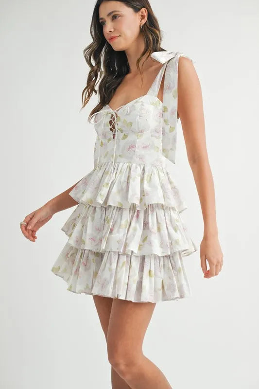 Off-white floral print layered mini dress with shoulder tie detail by Trendsi, featuring a stylish, feminine design.