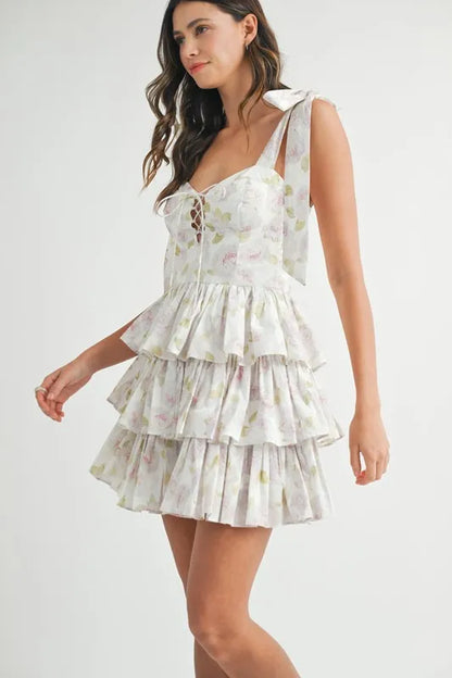 Off-white floral print layered mini dress with shoulder tie detail by Trendsi, featuring a stylish, feminine design.