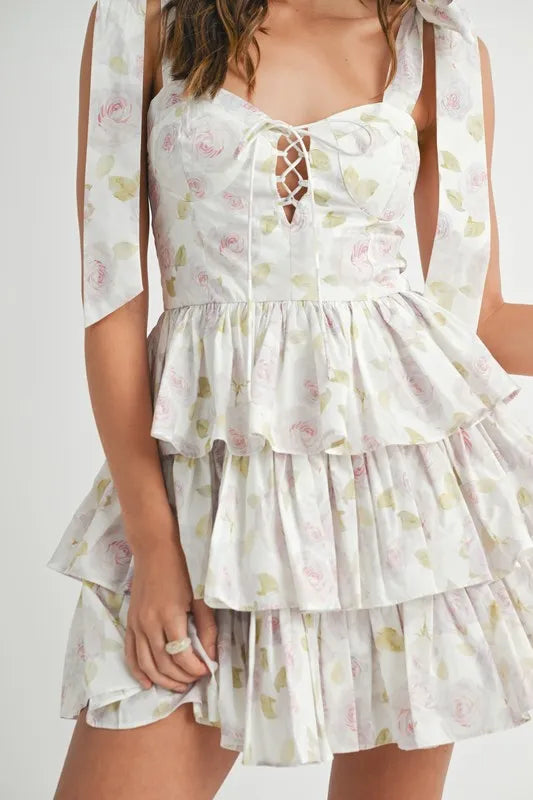 Off-white MABLE floral print shoulder tie layered mini dress by Trendsi, featuring a feminine design with ruffled layers and floral pattern.