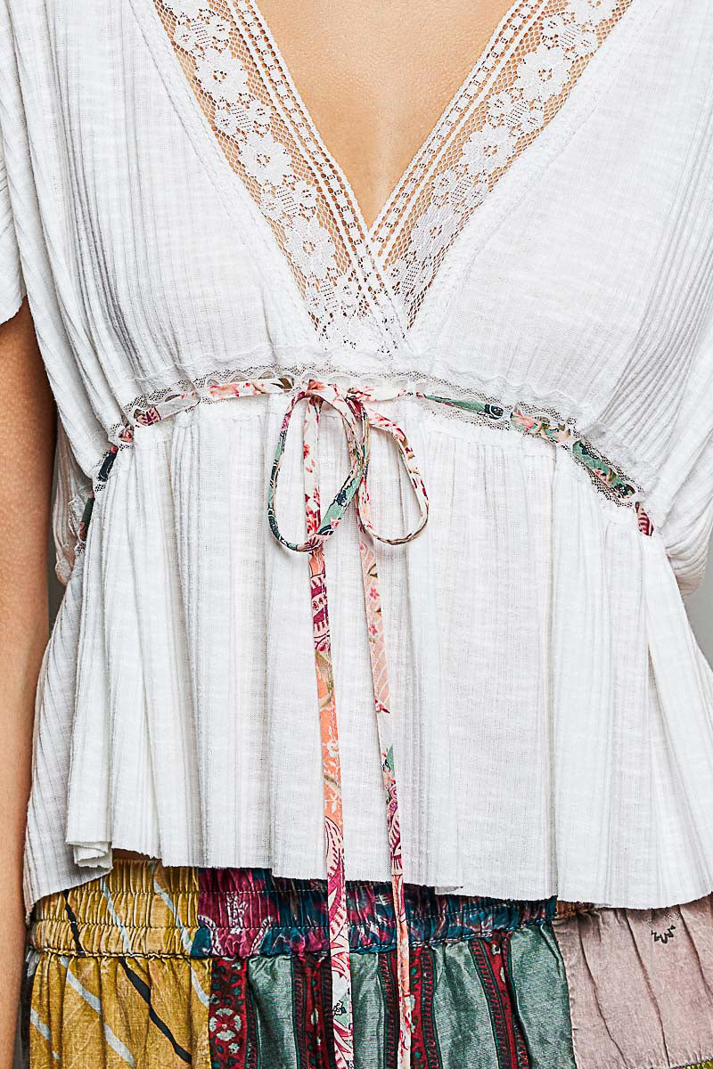 Off-white Trendsi POL tied ruffled V-neck short sleeve blouse with lace detail, showcasing feminine design and lightweight fabric.