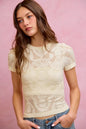 Off-white floral perforated seamless active short sleeve top by Trendsi, designed for comfortable athletic wear.