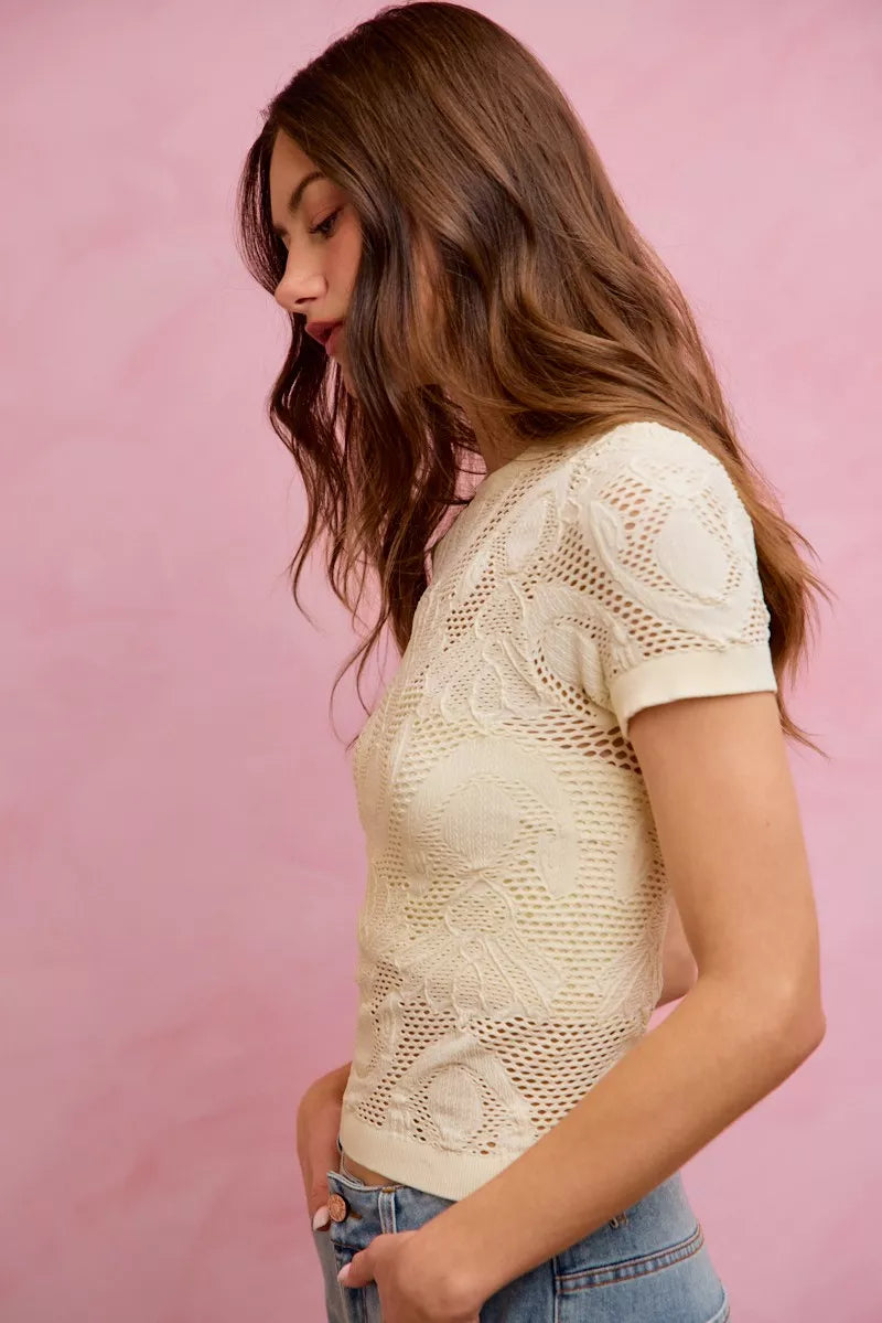 Off-white floral perforated seamless active short sleeve top by Trendsi, designed for comfort and breathability.