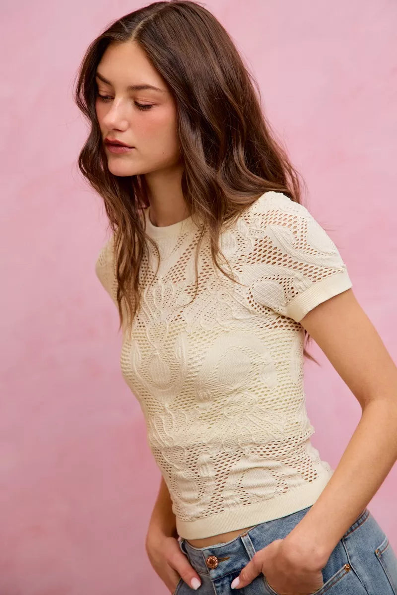 Off-white floral perforated seamless active short sleeve top by Trendsi, designed for comfort and breathability during workouts.