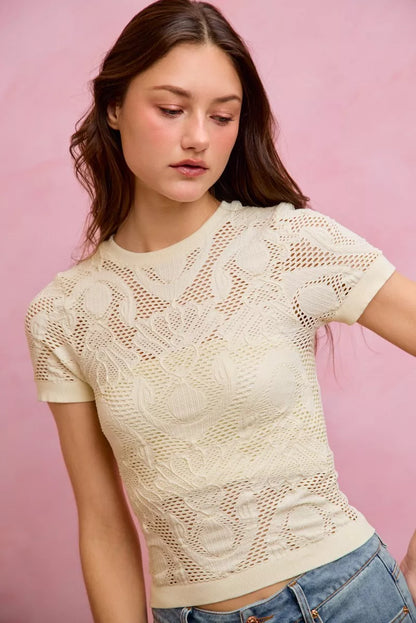 Off-white floral perforated seamless active short sleeve top by Trendsi, showing lightweight, breathable fabric with floral design.