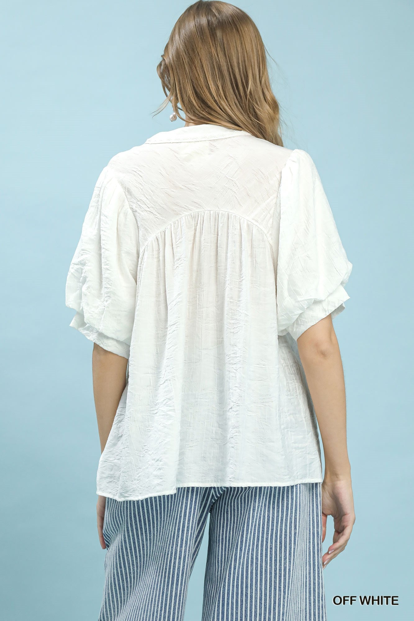 Off-white Umgee boho blouse with textured lace trim and V-neck, featuring relaxed fit and lightweight fabric.