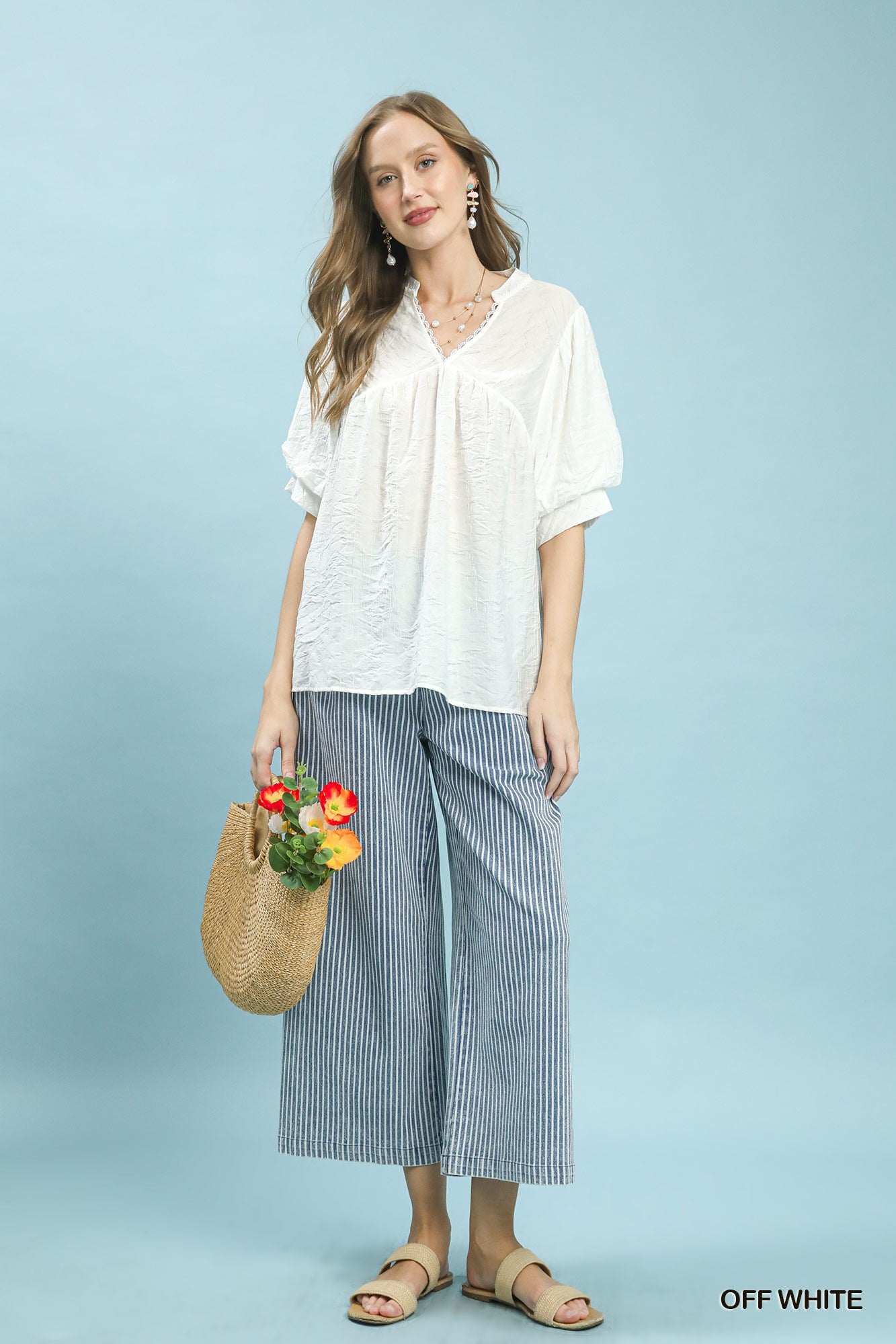 Off-white Umgee boho blouse with textured lace trim and V-neck, featuring a relaxed fit and stylish design.