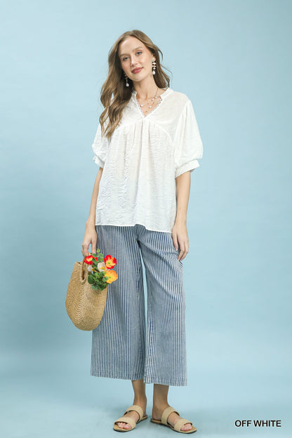 Off-white Umgee boho blouse with textured lace trim and V-neck, featuring a relaxed fit and stylish design.
