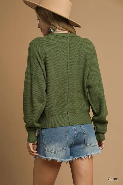 Olive green Umgee chunky cable knit V-neck button-up cardigan with long sleeves and ribbed trim, stylish and cozy for fall.