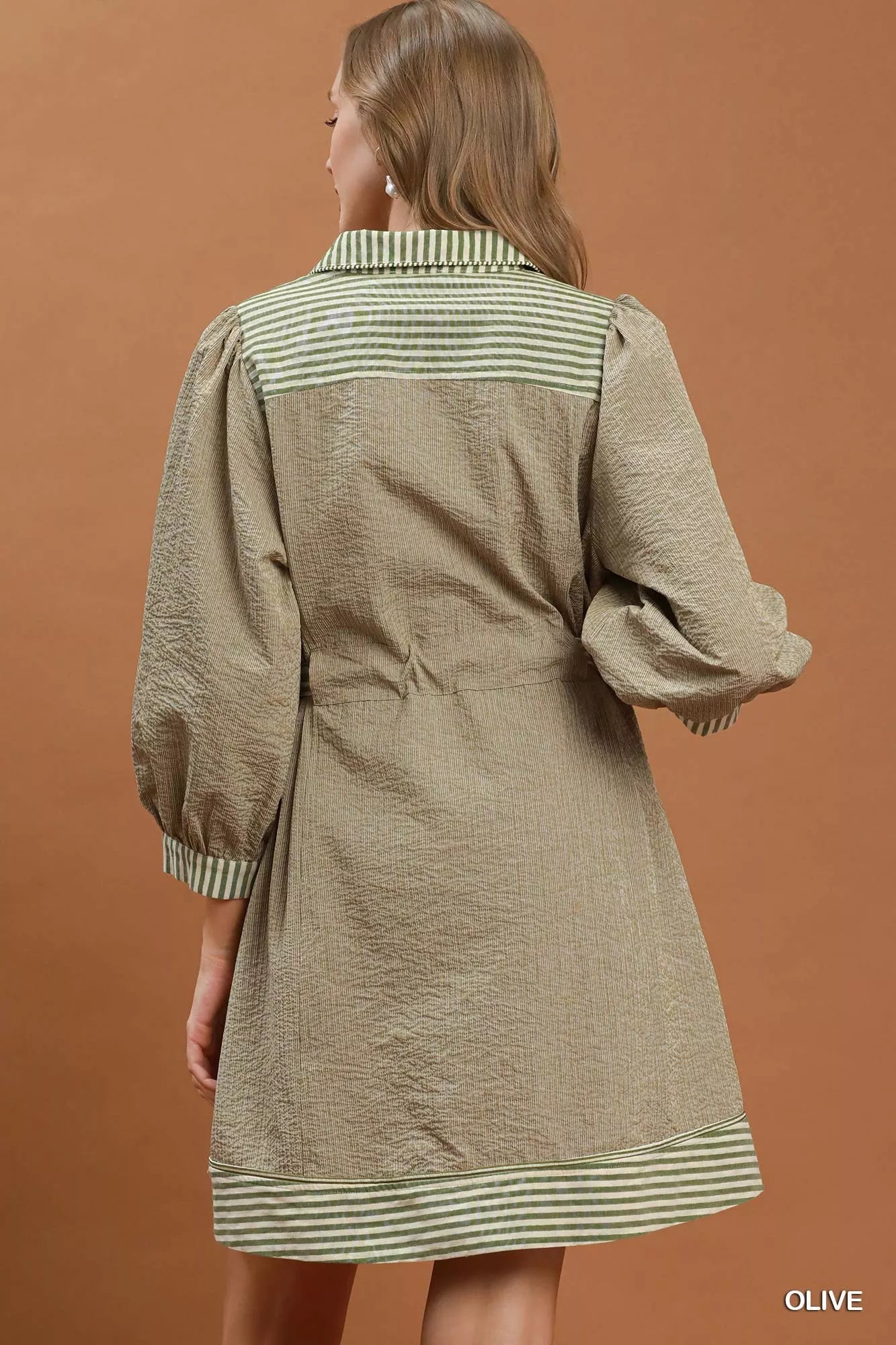 Olive green Umgee mini dress with striped contrast details, puff sleeves, and a belt, perfect for casual wear.
