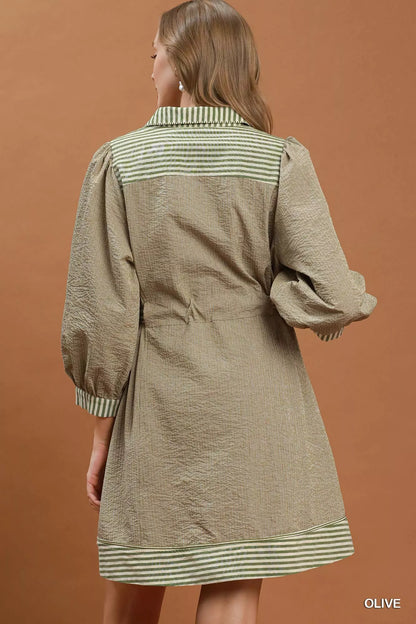 Olive green Umgee mini dress with striped contrast details, puff sleeves, and a belt, perfect for casual wear.