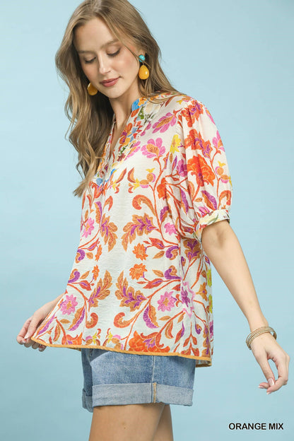 Orange floral split-neck short sleeve top by Umgee, trendy casual blouse with mixed floral pattern and relaxed fit.