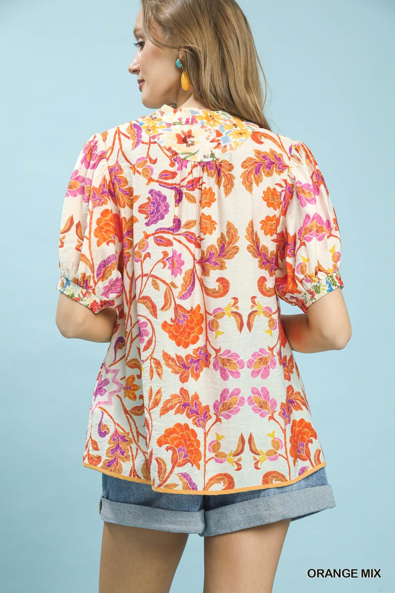 Orange floral split-neck short sleeve top by Umgee with a relaxed fit and mixed floral pattern.