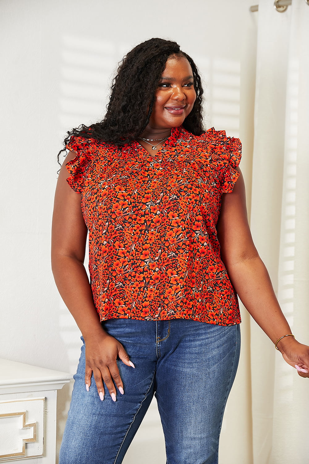 Orange-red floral flutter sleeve blouse with notched neckline from Trendsi, featuring a stylish and feminine design.