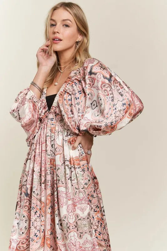 Pale blush ADORA printed V-neck batwing sleeve dress by Trendsi, shown on a model with a flowy, stylish silhouette.