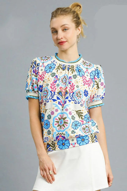 Pastel blue Umgee retro floral puff sleeve top with ruffled details, displayed on a model, perfect for casual or boho styles.