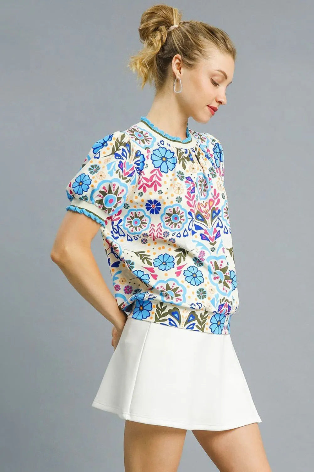 Pastel blue Umgee retro floral puff sleeve top with ruffled details, styled by Trendsi, showcasing its vintage-inspired design and feminine fit.