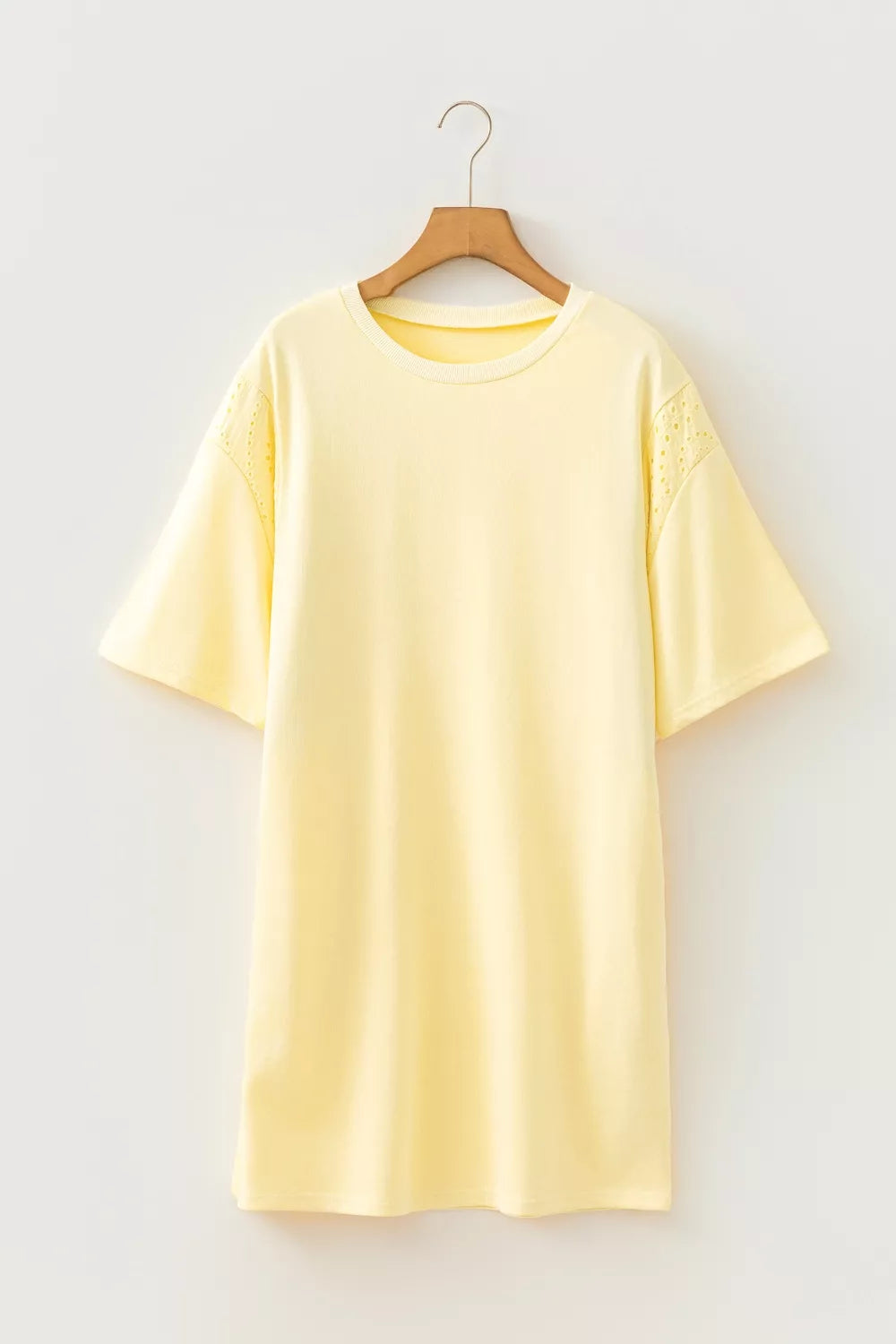 Pastel yellow Trendsi round neck half sleeve T-shirt dress displayed on a hanger, showcasing its casual, comfortable style.