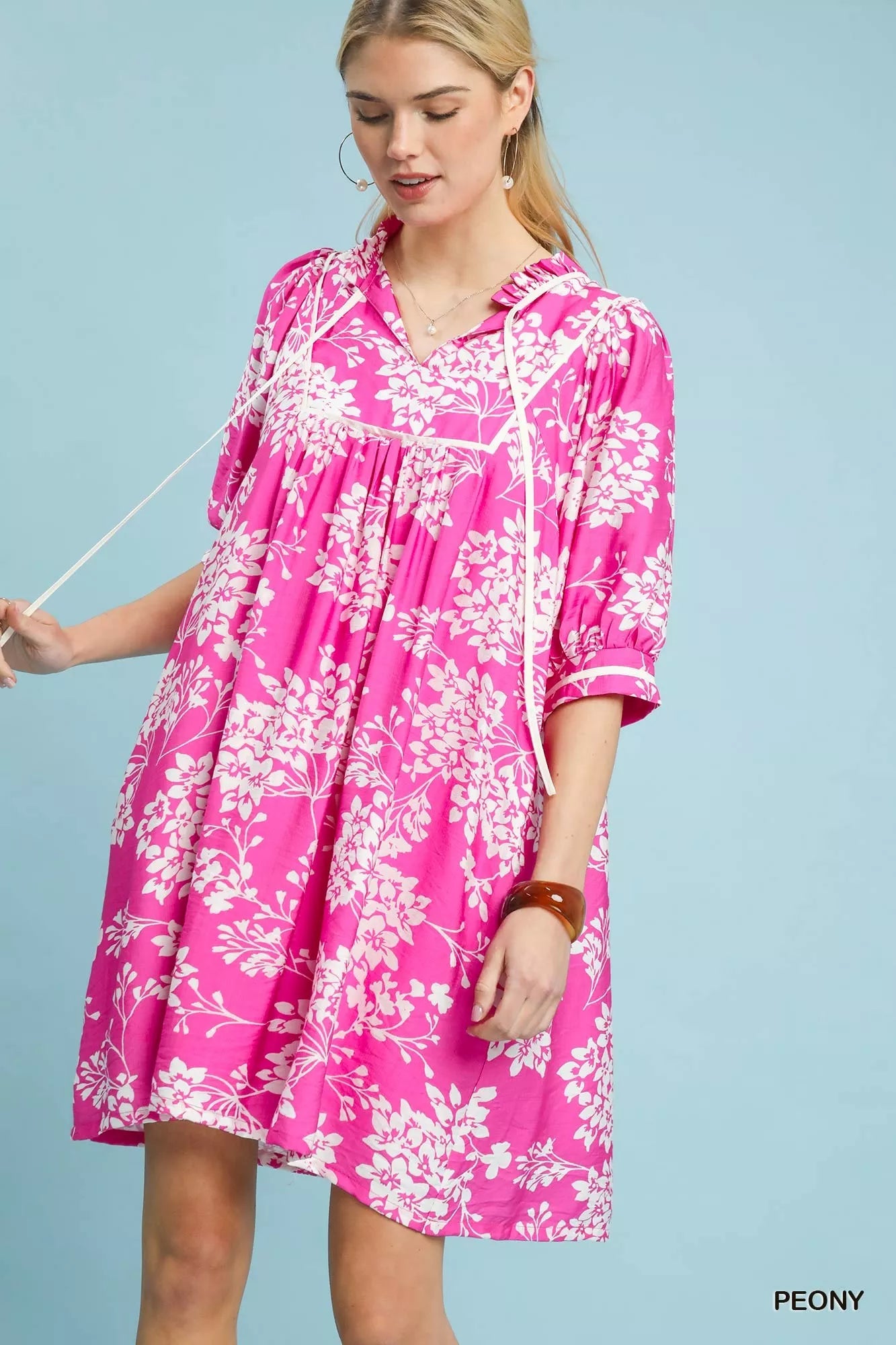 Umgee floral babydoll dress with pockets, featuring a flowy silhouette and vibrant floral pattern, perfect for casual wear.
