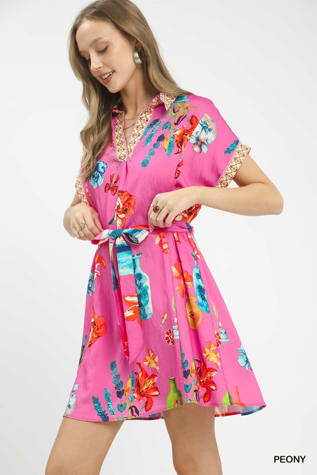 Umgee floral print mini dress with belt, featuring a vibrant pattern and stylish waist tie, perfect for casual or summer wear.