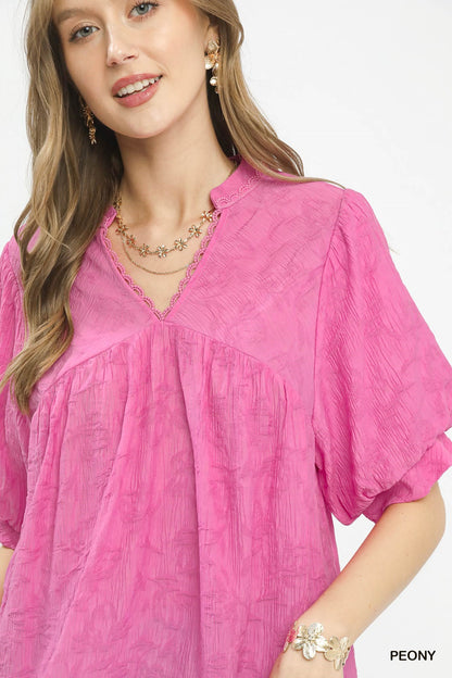 Umgee textured lace trim V-neck boho blouse with long sleeves and relaxed fit, styled with casual accessories.