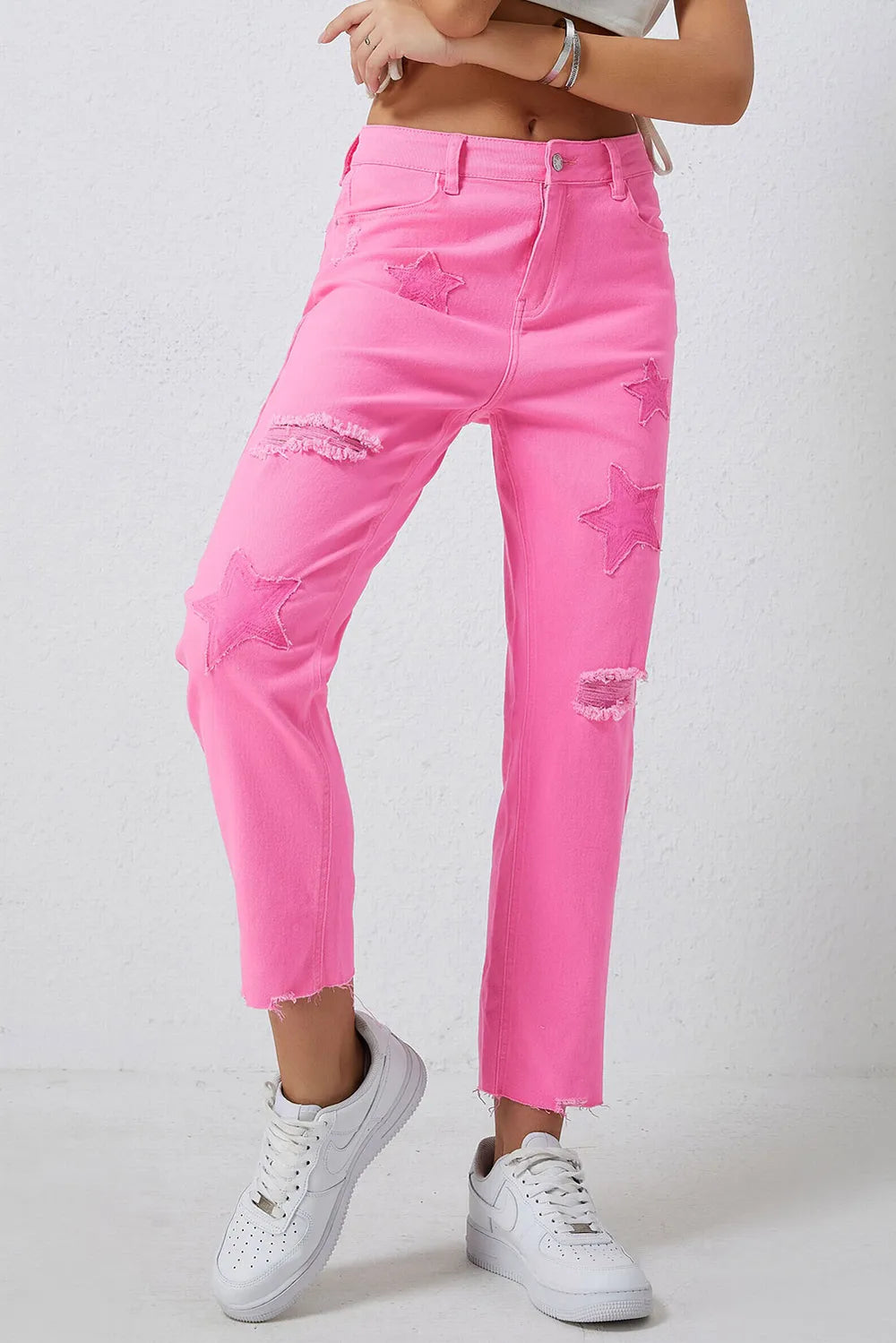 Pink distressed jeans with raw hem from Trendsi featuring a relaxed fit and distressed detailing.
