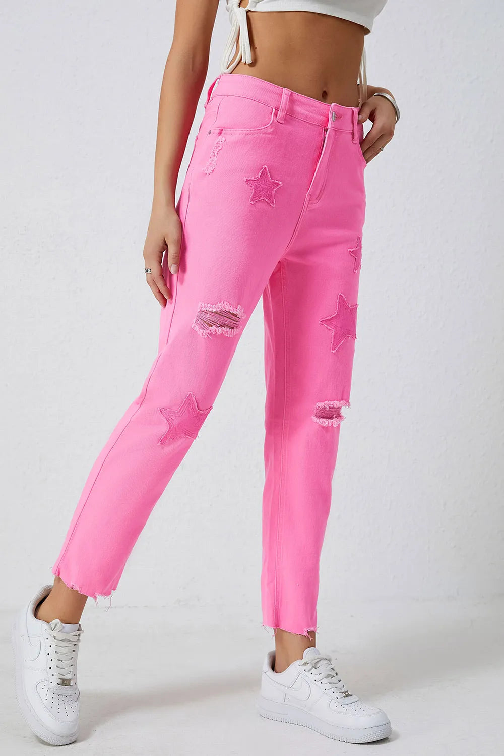 Pink distressed jeans with raw hem from Trendsi, featuring a relaxed fit and trendy distressed details.