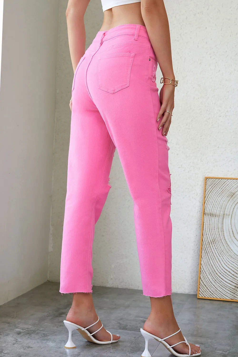 Pink distressed jeans with raw hem from Trendsi featuring a casual, ripped design and relaxed fit.