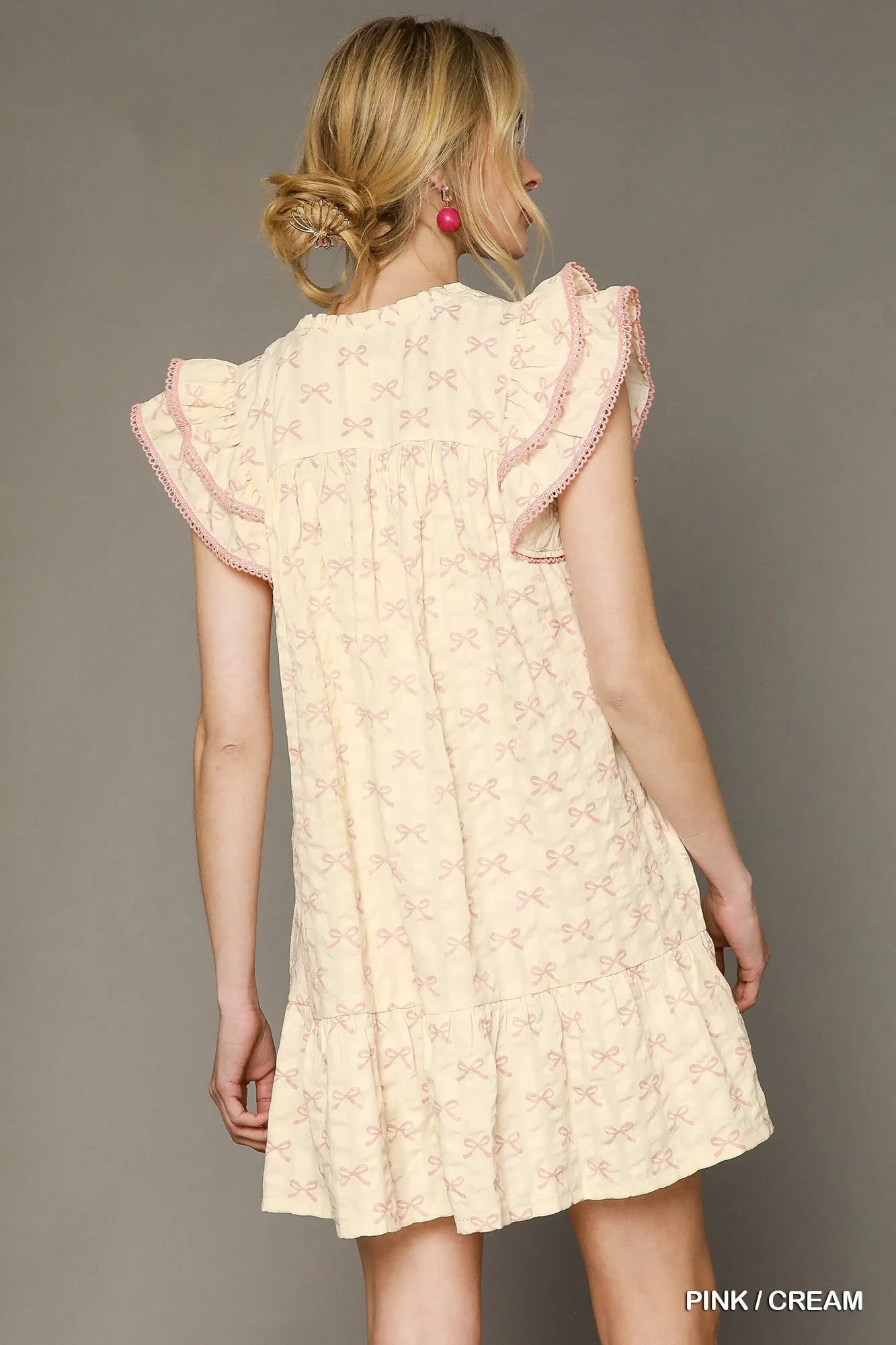 Pink and cream bow print mini dress by Umgee featuring ruffled cap sleeves and a feminine, stylish design.