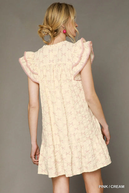 Pink and cream bow print mini dress by Umgee featuring ruffled cap sleeves and a feminine, stylish design.