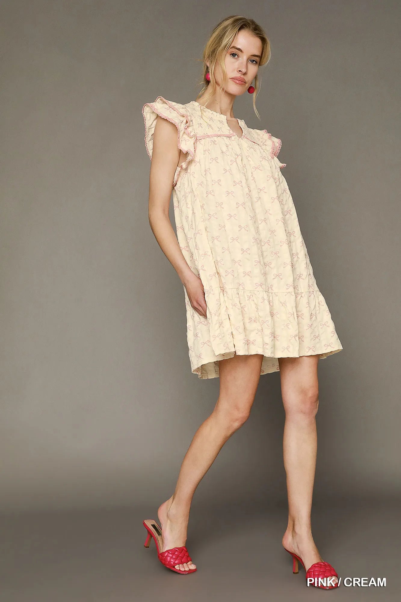 Pink and cream bow print mini dress by Umgee with ruffled cap sleeves, perfect for casual or dressy occasions.