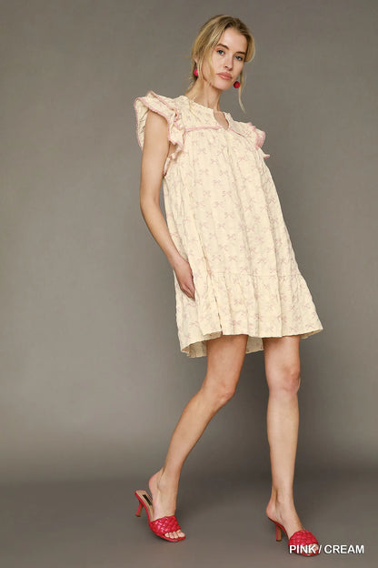 Pink and cream bow print mini dress by Umgee with ruffled cap sleeves, perfect for casual or dressy occasions.