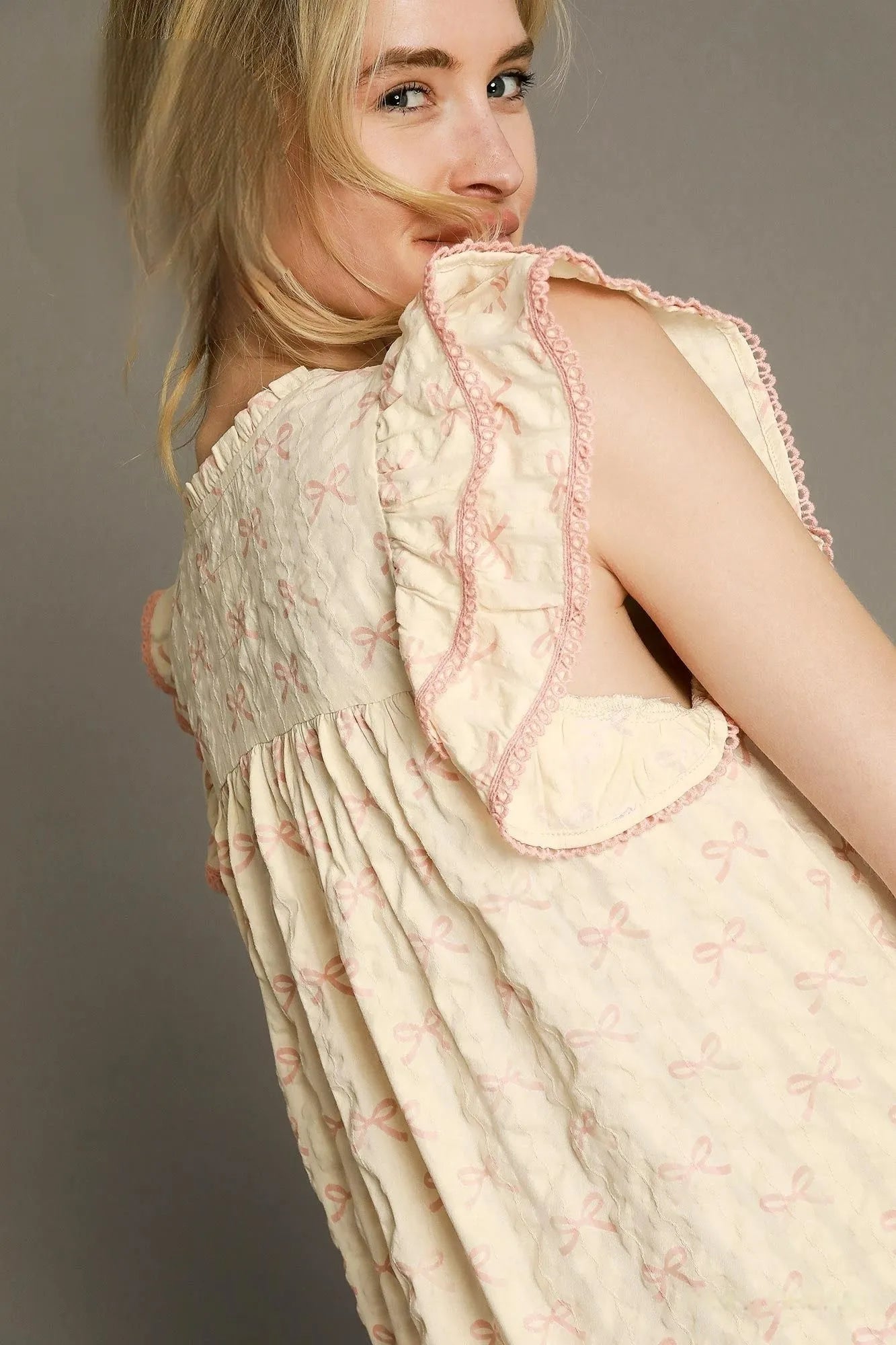 Pink and cream bow print mini dress by Umgee with ruffled cap sleeves, perfect for casual or summer wear.
