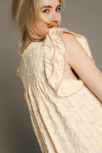 Pink and cream bow print mini dress by Umgee with ruffled cap sleeves, perfect for casual or summer wear.