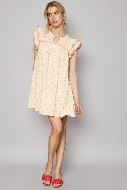 Pink and cream bow print mini dress by Umgee with ruffled cap sleeves, perfect for casual or semi-formal occasions.