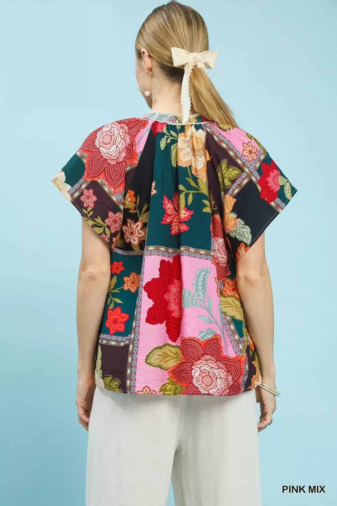 Pink floral patchwork tassel tie top by Umgee, featuring mixed patterns and a stylish tassel detail, perfect for casual wear.