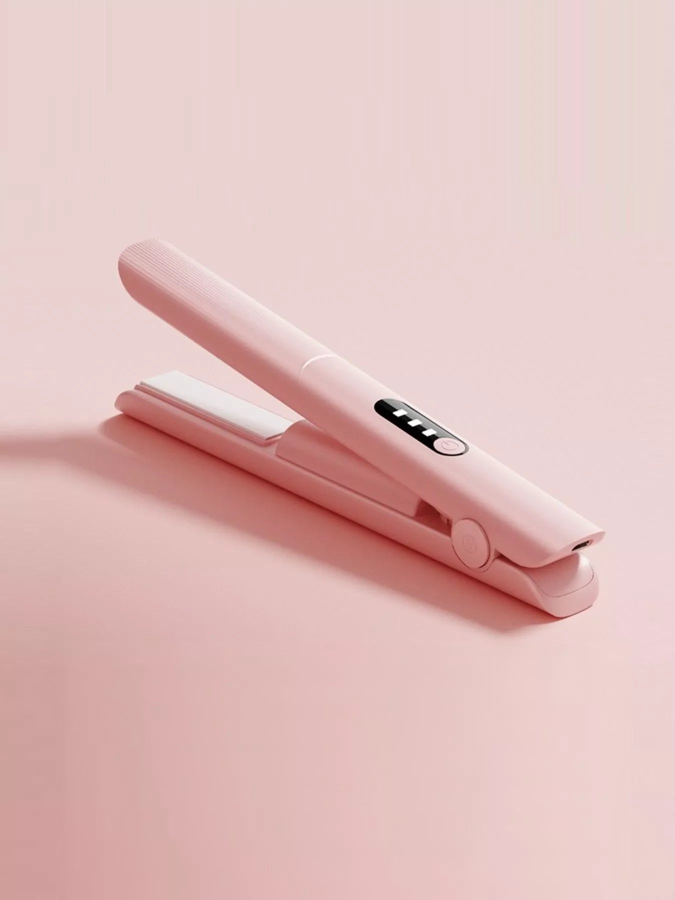 Pink rechargeable hair straightener from Trendsi with sleek design and ceramic plates for smooth, straight hair styling.