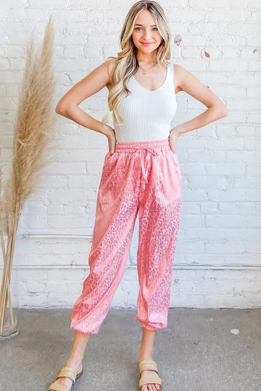 Pink satin leopard print joggers from Trendsi featuring a relaxed fit and stylish design.