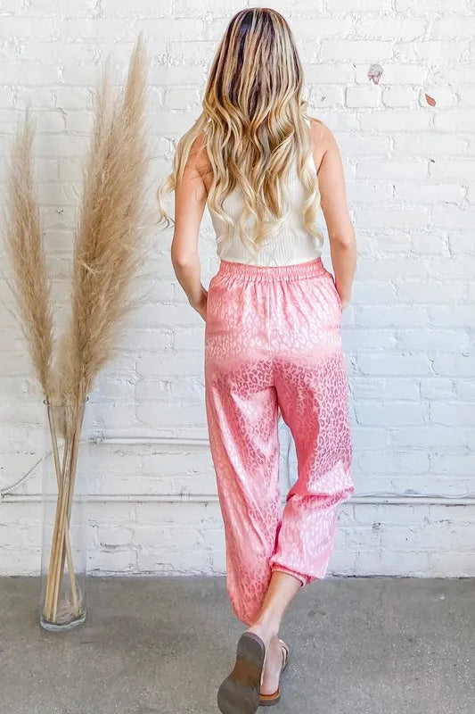 Pink satin leopard print joggers from Trendsi featuring a relaxed fit and stylish animal print design.