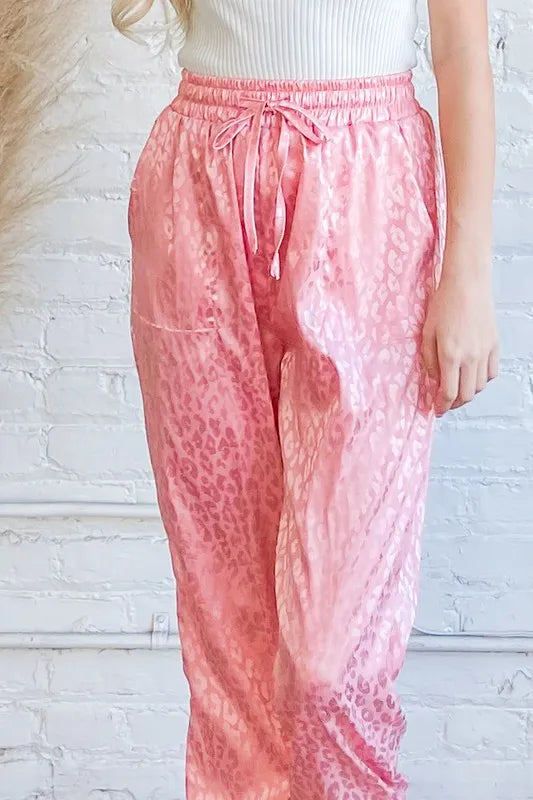 Pink satin leopard print joggers from And The Why by Trendsi, featuring a stylish, relaxed fit and bold animal print design.