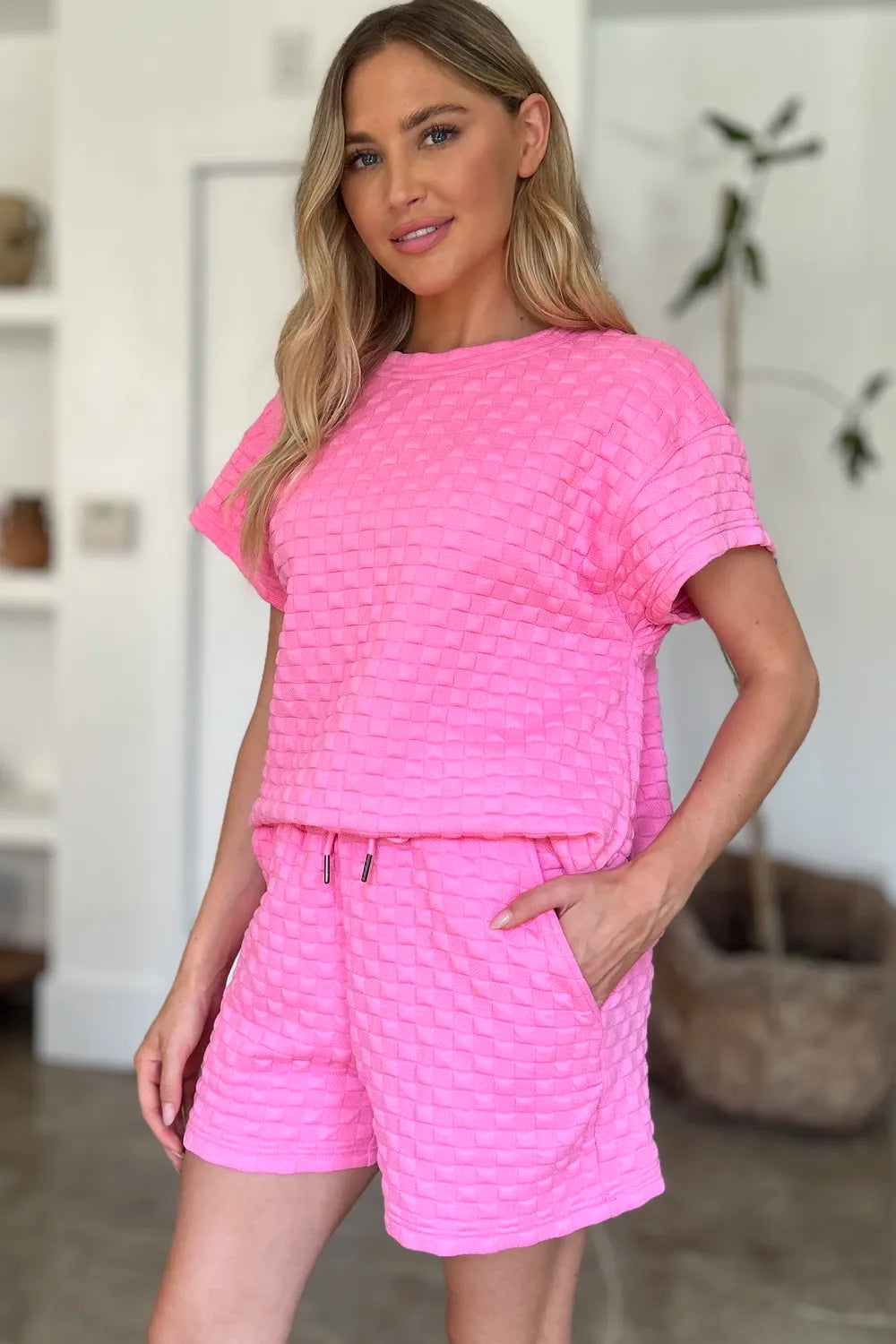 Pink Trendsi Double Take full-size texture T-shirt and shorts set displayed on a hanger, featuring soft fabric and casual style.