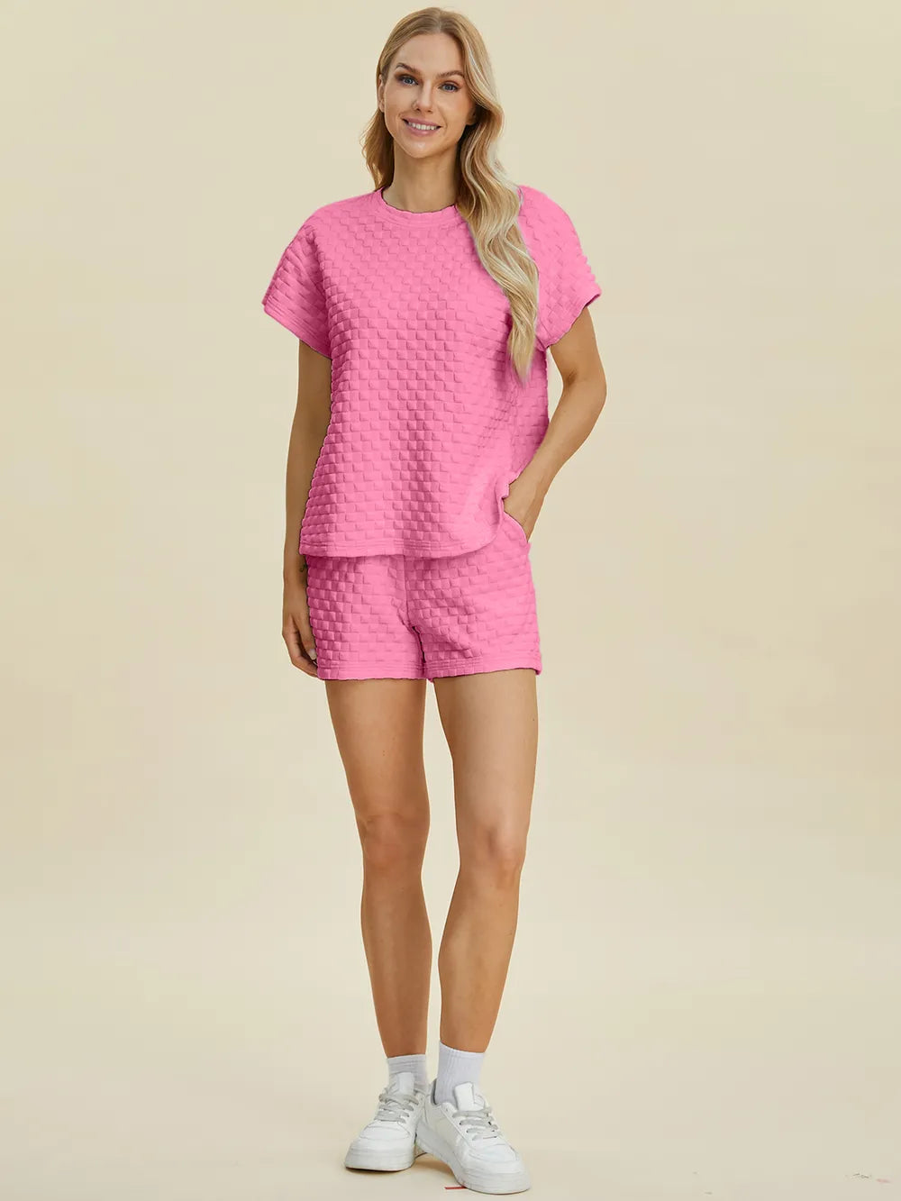 Pink Trendsi Double Take full-size textured T-shirt and shorts set displayed on a model. Casual, comfortable, stylish activewear ensemble.