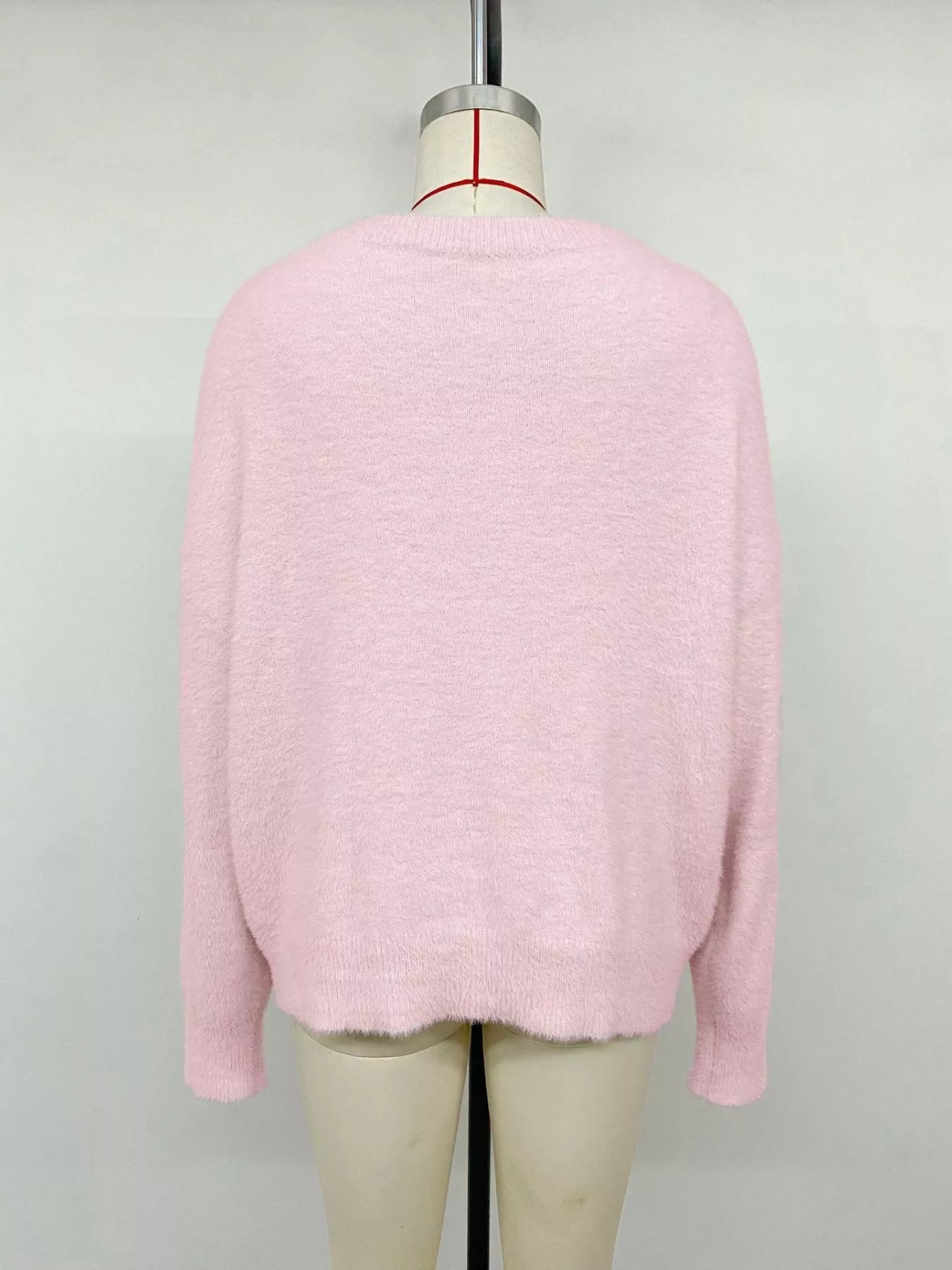 Pink fluffy long sleeve sweater by Trendsi, cozy knit top with a soft, textured fabric and relaxed fit for casual wear.