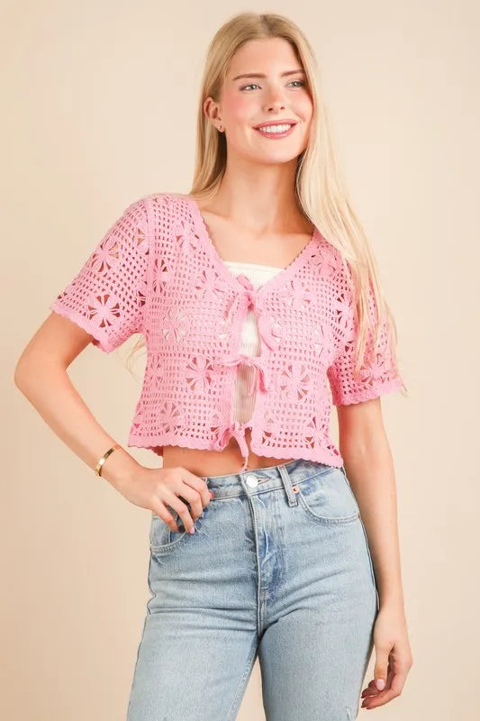 Pink Very J crochet crop top with front tie, short sleeves, and open-knit design, styled for casual summer wear.