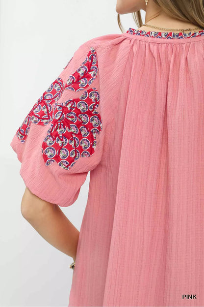 Pink Umgee embroidered sleeve contrast trim top with decorative embroidery and stylish sleeve details.